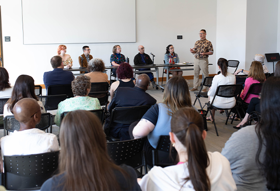 A candid photograph of a diverse audience attending a presentation in a modern conference room.